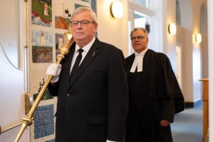 The sergeant-at-arms carries the mace into the Legislative chamber with Speaker following behind